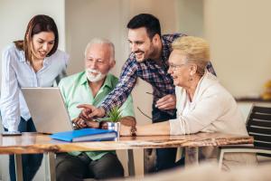 Ehrenamtliche Personen helfen Senioren am Computer