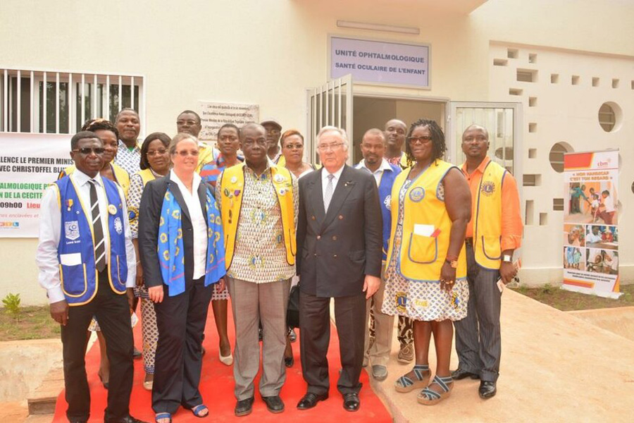 2013 Togo -  Gruppenbild mit togoischen Lions: die damals amtierende Governorratsvorsitzende der deutschen Lions, Barbara Grewe und HDL-Vorstandssprecher Prof. Dr. Jörg-Michael Kimmig vor dem neuen Gebäude,der Kinderaugenklinik in Togo.