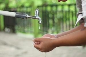 2021 Indien - Kinderhände unter einem Wasserhahn