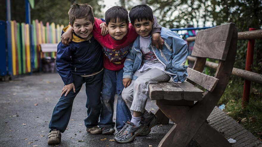 Drei glückliche Kinder aus dem Friedensdorf Oberhausen lächeln in die Kamera